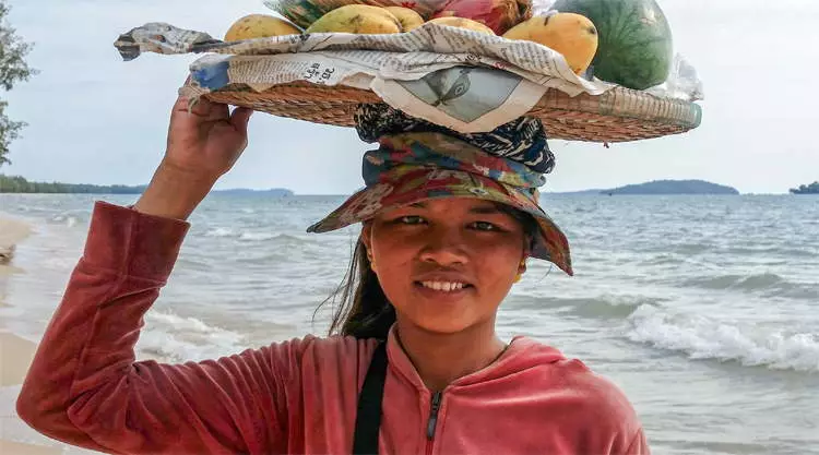 Vrouw verkoopt fruit op het strand bij Sihanoukville