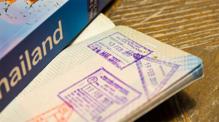 Paspoort met visa exemption stempels, Lonely Planet Thailand op tafel